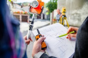 Close-up of Surveyors Planning and Reading a Map of City Streets.